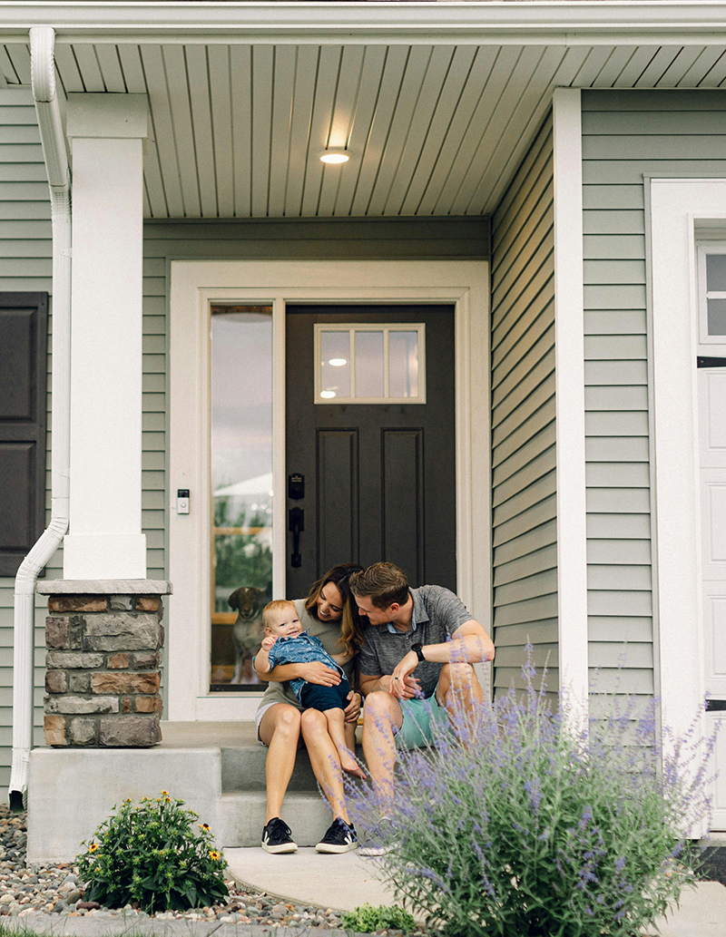 Young family sitting outside of new home in Lake County, FL